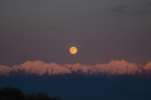 Moon above snowy mountains